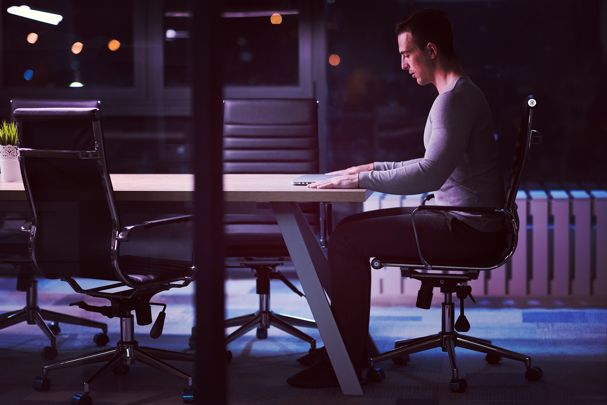 man working on laptop in dark office sedentary work | RAD Roller Hungary